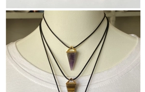 Detail of amethyst and tiger eye stone geometric pyramid pendants on black cords