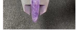 Vue macro de l'épaisseur du cœur en pierre violette mesurée avec un pied à coulisse