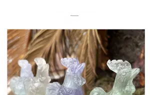 Detailed view of hand-carved natural fluorite rooster statues in purple and green hues