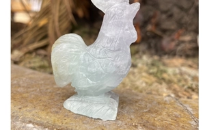 Detailed view of hand-carved green fluorite rooster statue with semi-transparent texture