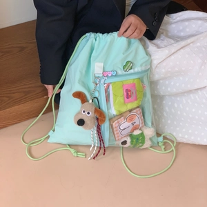 Detail of mint green ita backpack with transparent PVC window and cute plush dog pendant