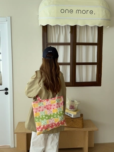 Détails d'un grand sac cabas en toile à motif floral patchwork porté par un mannequin