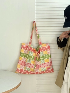 Détail du sac cabas patchwork floral avec cordon de serrage et ornements en perles
