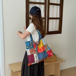 Détail du sac cabas patchwork multicolore avec imprimés floraux et anses à carreaux