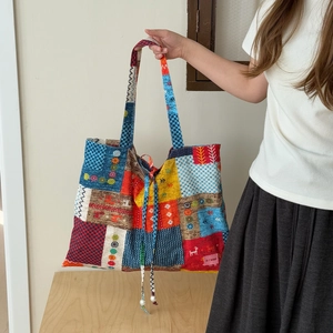 Détail du sac cabas patchwork bohème avec motifs variés et cordon à perles blanches