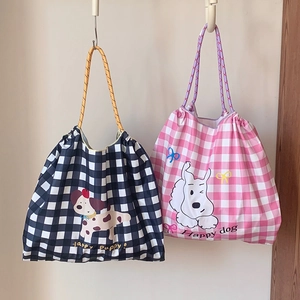 Détail de sacs fourre-tout en toile à carreaux avec écussons chiot et anses en corde tressée