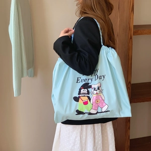 Détail du grand sac cabas bleu clair avec motifs cartoon et sangle tissée souple