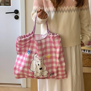 Détail du sac cabas à carreaux roses avec motif chien et poignée tissée violette