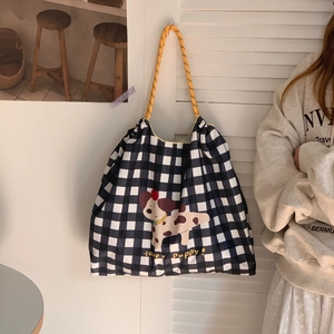 Détail du sac cabas à carreaux avec imprimé chiot et bandoulière tissée jaune