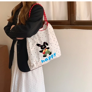 Vue détaillée d'un sac cabas en toile à pois avec impression de lapin mignon de profil