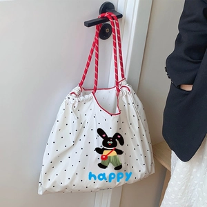 Détail du sac fourre-tout à pois blancs avec lapin cartoon et poignée tressée rouge