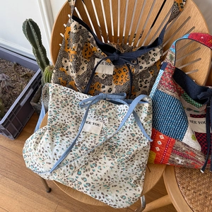 Dettaglio di tre grandi borse tote in denim con motivi leopardati e geometrici