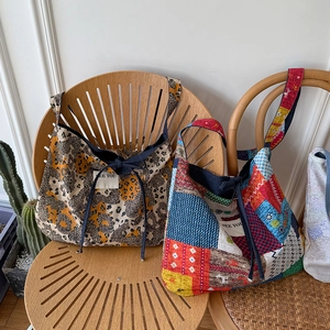 Dettaglio di borse tote in tela stampata leopardata con etichette in tessuto 'SEE YOU'