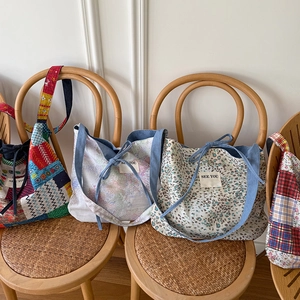 Dettaglio di borse in tela denim con motivi floreali e design patchwork in stile etnico