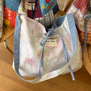 Dettaglio della borsa tote patchwork floreale con finiture in denim e coulisse