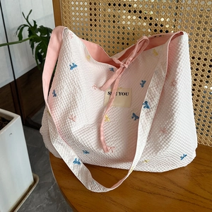 Sac fourre-tout rose à carreaux avec broderies nœuds et patch 'SEE YOU' sur une chaise
