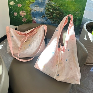 Détail du sac cabas rose gaufré avec des nœuds brodés colorés pour femmes élégantes