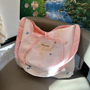 Détail du sac cabas à carreaux avec broderies florales et nœud en ruban rose