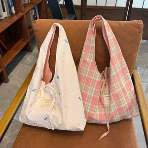 Détail de texture matelassée et sacs cabas à carreaux avec étiquette tissée