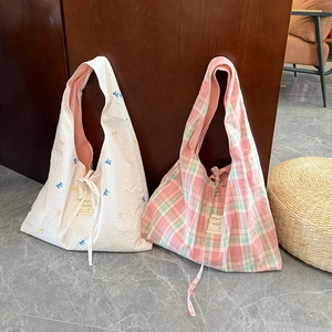 Détail du sac cabas à carreaux avec broderie, nœud de fermeture et doublure rose doux
