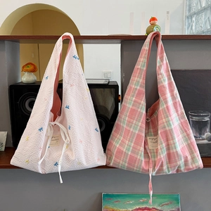 Détail de broderie nœud et motifs à carreaux sur des sacs à bandoulière de printemps