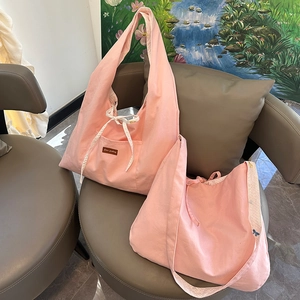 Détail du sac hobo en toile rose avec sangle florale, cordon de serrage et patch en cuir