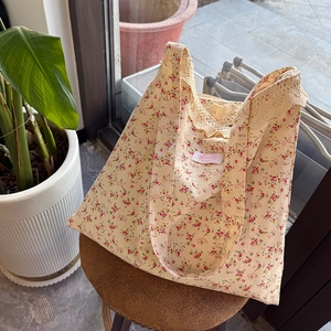 Détail d'un sac à main floral avec dentelle et motifs de fleurs roses sur un tabouret