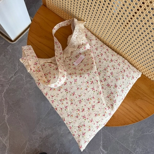 Vue détaillée du sac cabas en toile à fleurs avec bordure en dentelle crème et motif floral