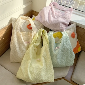 Detail of bubble texture tote bags in pastel colors with Have a nice day label