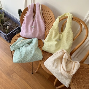Dettaglio della trama a bolle su borse tote color pastello in rosa, giallo e verde