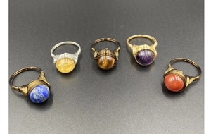 Detailed view of handmade wire-wrapped gemstone rings featuring lapis lazuli and amethyst stones