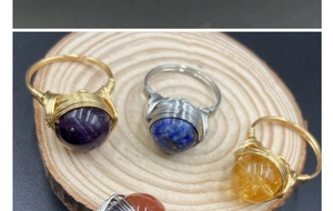 Detail of wire-wrapped rings with amethyst and lapis lazuli beads on wood slices
