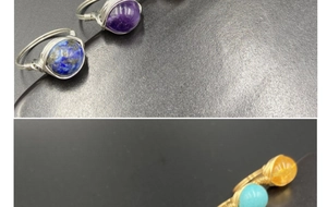 Detailed macro view of four handmade wire-wrapped gemstone rings in vintage white gold finish