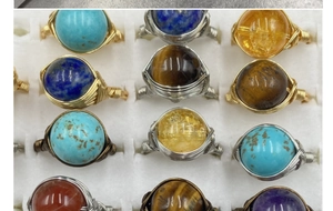 Detail of handmade wire-wrapped gemstone rings with amethyst and lapis lazuli beads