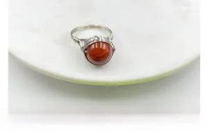 Macro shot of handmade wire wrapped red agate ring with silver finish gemstone detail