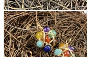 Macro detail of handmade wire-wrapped pendants with colorful stone beads and golden star weave