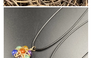 Detailed close-up of multi-color chakra stones wrapped in golden wire pendant