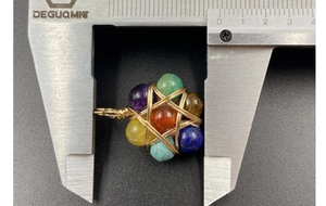 Detailed macro view showing the 25mm width of a wire-wrapped multi-color stone pendant