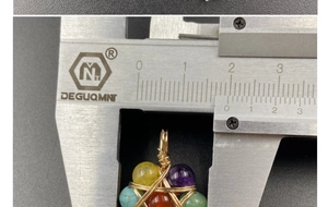 Macro shot measuring the handmade 7 chakras hexagram pendant with a digital caliper