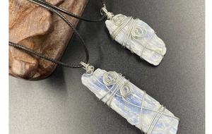 Vue détaillée de pendentifs en cyanite bleue brute avec fil d'argent et cordons cirés