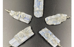 Détail de pendentifs en cyanite bleue brute avec un emballage artisanal en fil argenté