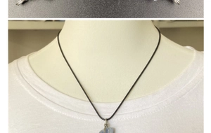 Détail d'un pendentif en cyanite bleue brute enroulé de fil sur un collier noir