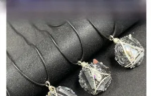 Détail de colliers avec pendentifs en pierre noire et perles enveloppés de fils d'argent