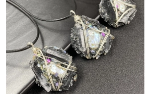 Gros plan de pendentifs en cristal faits main avec fil d'argent et cordons tissés