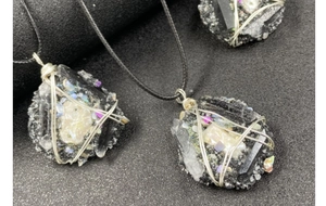 Détail d'un pendentif fait main en tourmaline noire avec fil enroulé et cordon tressé