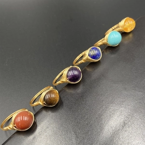 Handmade gold wire wrapped rings set featuring various natural gemstones on black background