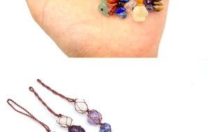 Detail of assorted raw natural crystal stones wrapped in brown woven net pendants
