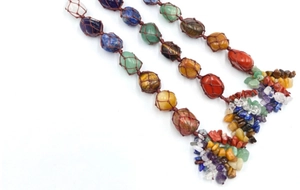 Detail of handmade woven net holding colorful natural raw healing crystals and stones