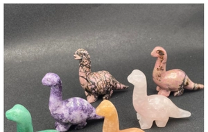Detailed view of hand-carved natural gemstone dinosaur figurines in various colors
