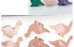 Macro shot of assorted natural crystal dinosaur carvings and secure foam packaging